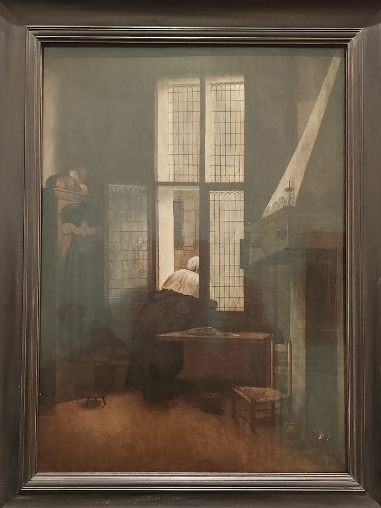 (23) Femme penchée à la fenêtre. 1654. Huile sur panneau 66,5 x 47,4cm signée et datée. Vienne Kunsthistorisches Museum. Une femme peinte de dos regarde par la fenêtre absorbée par ce qu’elle voit, les ciseaux sur la table suggérant un travail interrompu.